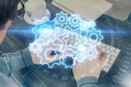 Double exposure of businessman working on laptop on background. International business hologram in...