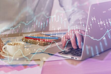 Forex graph with businessman working on computer in office on background. Concept of hardworking....