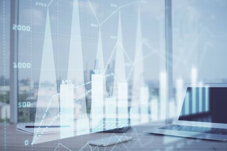 Forex graph hologram on table with computer background. Multi exposure. Concept of financial markets.の写真素材
