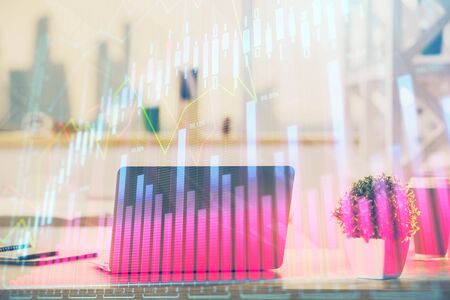 Forex market chart hologram and personal computer background. Double exposure. Concept of investment.の写真素材