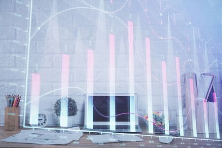 Stock market chart hologram drawn on personal computer background. Multi exposure. Concept of investment.の写真素材