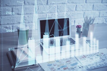 Stock market chart hologram drawn on personal computer background. Multi exposure. Concept of investment.の写真素材
