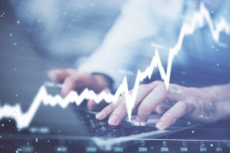 Forex graph with businessman typing on computer in office on background. Concept of analysis. Double...