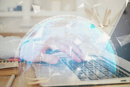 Multi exposure of businessman working on laptop on background. International business hologram in front. Concept of success.の写真素材