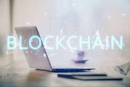 Double exposure of blockchain and crypto economy theme hologram and table with computer background....