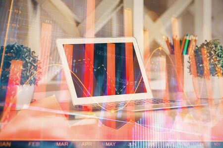 Financial chart drawing and table with computer on background. Multi exposure. Concept of international markets.の写真素材
