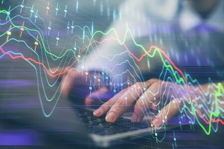 Forex graph with businessman working on computer in office on background. Concept of hardworking....