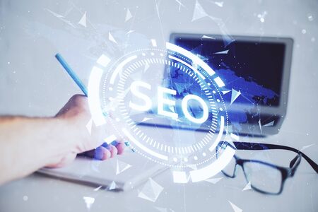 Man hands writing. With double exposure seo drawings.の写真素材