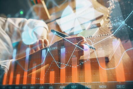 Financial forex charts displayed on womans hand taking notes background. Concept of research. Double...