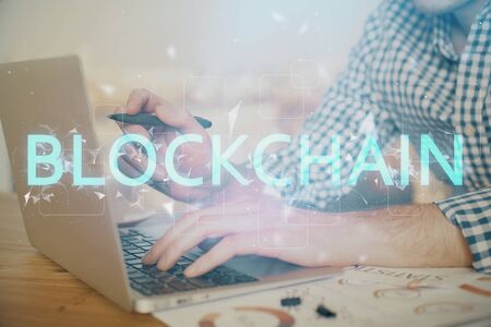Blockchain theme hologram with man working on computer on background. Concept of crypto chain. Double exposure.の写真素材