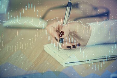 Multi exposure of hands making notes with forex chart huds. Stock market concept.の写真素材