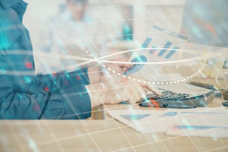 Double exposure of graph with man typing on computer in office on background. Concept of hard work....