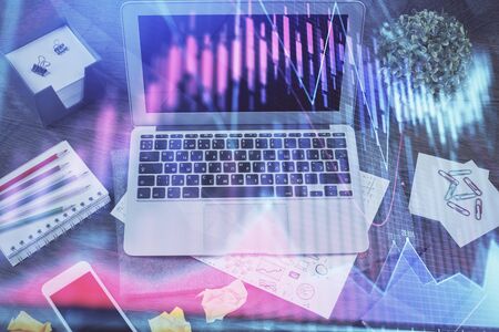 Financial graph colorful drawing and table with computer on background. Double exposure. Concept of international markets.の写真素材