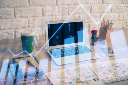 Financial graph colorful drawing and table with computer on background. Multi exposure. Concept of international markets.の写真素材