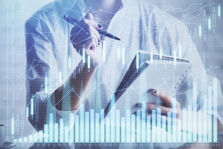 Financial chart drawn over hands taking notes