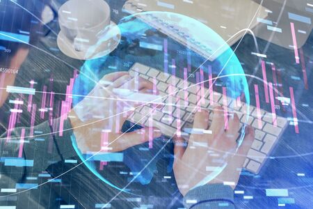 Double exposure of graph with man typing on computer in officeの写真素材