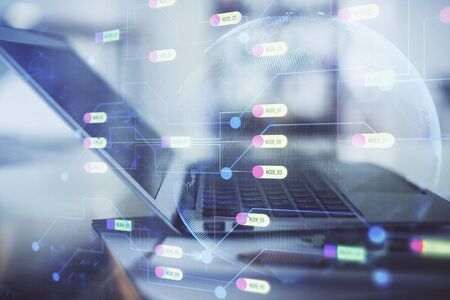 Double exposure of table with computer and data theme hologram.