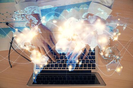 Multi exposure of businessman working on laptop on background. International business hologram in front. Concept of success.の写真素材