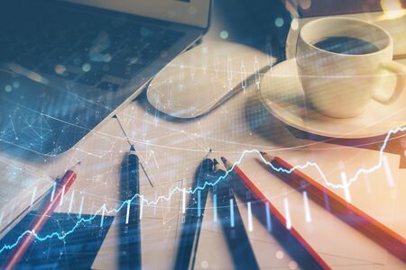 Financial market graph hologram and personal computer on background. Multi exposure. Concept of forex.の写真素材