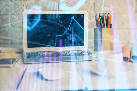 Stock market chart hologram drawn on personal computer background. Multi exposure. Concept of investment.の写真素材