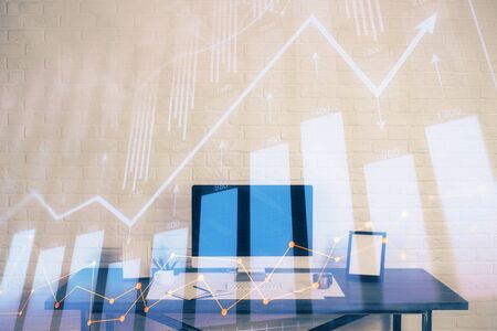 Stock market chart hologram drawn on personal computer background. Multi exposure. Concept of investment.の写真素材