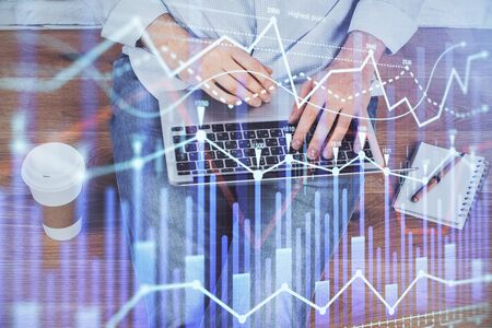 Double exposure of businessmans hands withcup of coffee with stock market graph background. Concept of research and trading.の写真素材