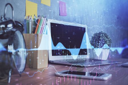 Financial graph colorful drawing and table with computer on background. Double exposure. Concept of international markets.の写真素材