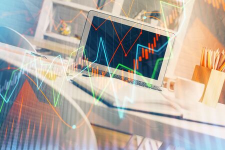 Forex market graph hologram and personal computer on background. Double exposure. Concept of investment.の写真素材