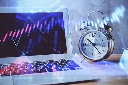 Forex market graph hologram and personal computer on background. Double exposure. Concept of investment.の写真素材