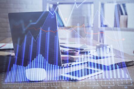 Financial chart drawing and table with computer on background. Double exposure. Concept of international markets.の写真素材