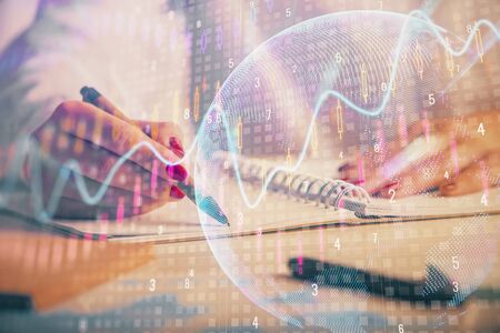 Double exposure of womans hands making notes with forex graph hologram. Concept technical analysis.の写真素材