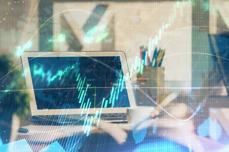 Financial chart drawing and table with computer on background. Multi exposure. Concept of international markets.の写真素材