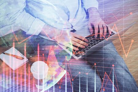 Double exposure of mans hands writing notes of stock market with forex graph background. Concept of research and trading.の写真素材
