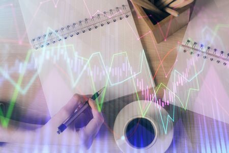 Multi exposure of hands making notes with forex chart huds. Stock market concept.の写真素材