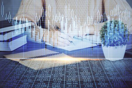 Forex graph on hand taking notes background. Concept of research. Double exposureの写真素材