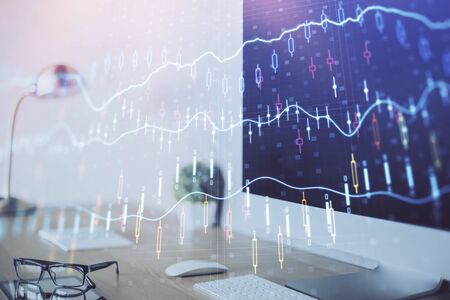 Forex graph hologram on table with computer background. Multi exposure. Concept of financial markets.の写真素材