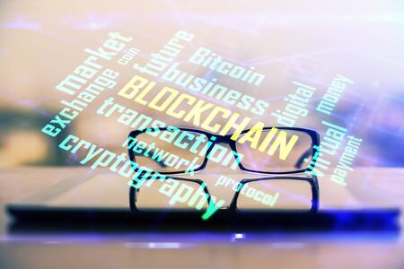 Crypto theme hologram with glasses on the table background. Concept of blockchain. Double exposure.の写真素材