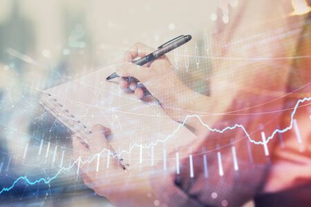 Multi exposure of hands making notes with forex chart huds. Stock market concept.