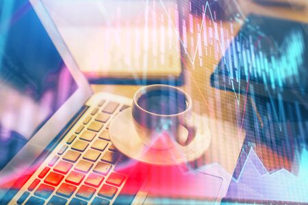 Forex market graph hologram and personal computer on background. Double exposure. Concept of investment.の写真素材