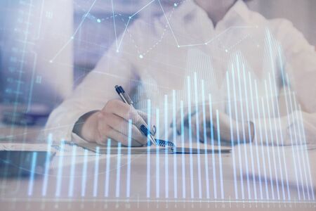 Financial chart drawn over hands taking notes background. Concept of research. Multi exposureの写真素材