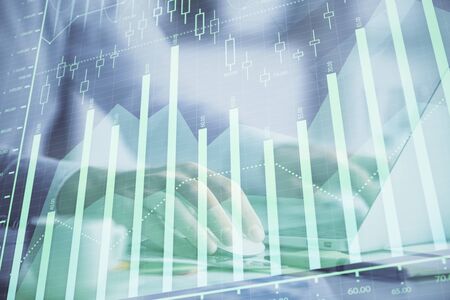 Double exposure of forex graph with man working on computer on background. Concept of market...