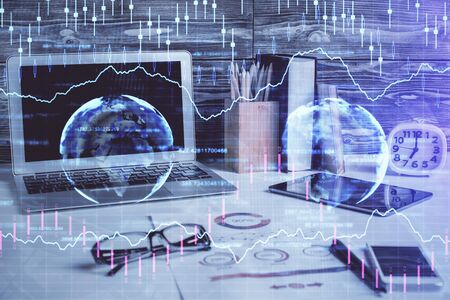 Double exposure of graph and financial info and work space with computer background. Concept of international online trading.の写真素材