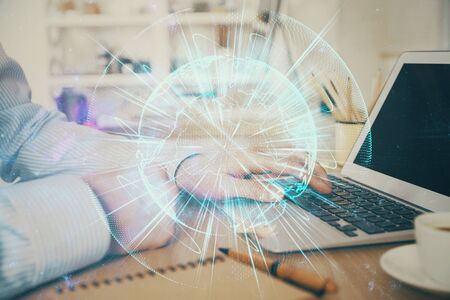 Multi exposure of businessman working on laptop on background. International business hologram in front. Concept of success.の写真素材