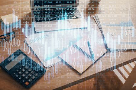 Double exposure of graph and financial info and work space with computer background. Concept of international online trading.の写真素材