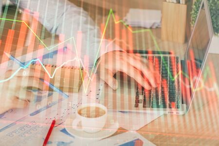 Forex graph with businessman working on computer in office on background. Concept of hardworking....