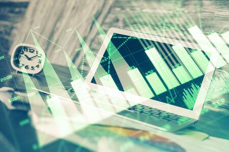 Financial graph colorful drawing and table with computer on background. Double exposure. Concept of international markets.の写真素材