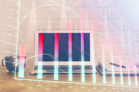 Stock market graph on background with desk and personal computer. Multi exposure. Concept of financial analysis.の写真素材