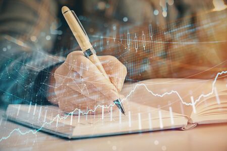 Multi exposure of womans hands making notes with forex graph hologram. Concept of technical analysis.の写真素材