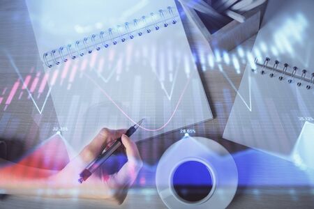Multi exposure of womans hands making notes with forex graph hologram. Concept of technical analysis.の写真素材