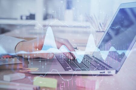 Double exposure of stock market graph with man working on laptop on background. Concept of financial analysis.の写真素材